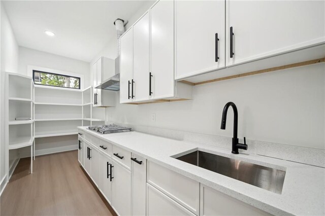 155 Westbrook St, Buford, GA 30518 - kitchen with light stone countertops, light wood-style flooring, white cabinetry, stainless steel gas cooktop, and a sink