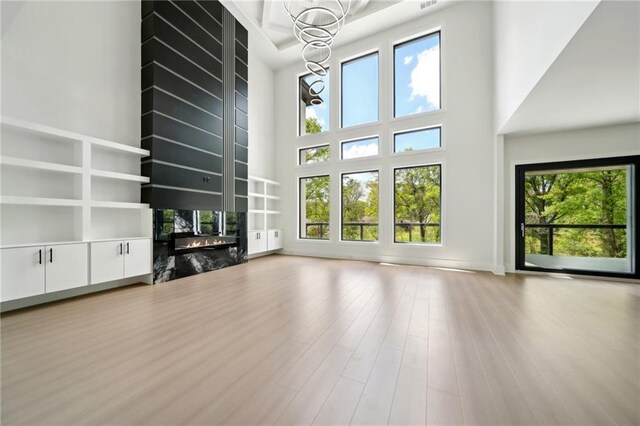 155 Westbrook St, Buford, GA 30518 - unfurnished living room with radiator, a fireplace, a towering ceiling, a chandelier, and wood finished floors