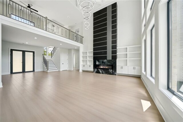 155 Westbrook St, Buford, GA 30518 - unfurnished living room with a premium fireplace, wood finished floors, a towering ceiling, and stairs