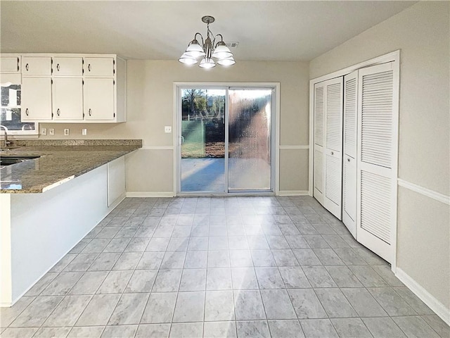 unfurnished dining area featuring light tile patterned floors and an inviting chandelier