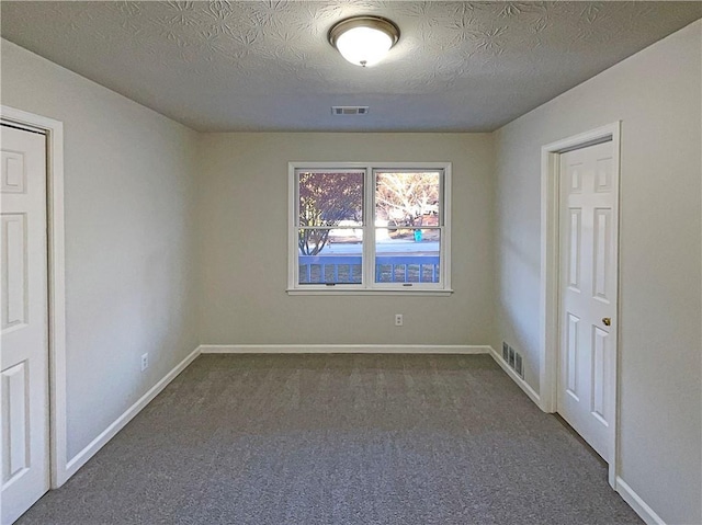 carpeted spare room with a textured ceiling