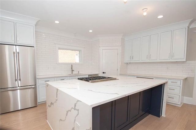 kitchen featuring white cabinets, a kitchen island, sink, and stainless steel appliances