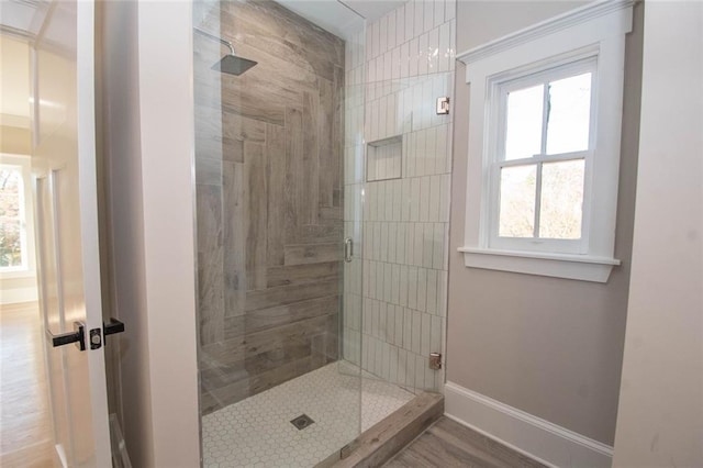 bathroom with hardwood / wood-style flooring, a healthy amount of sunlight, and an enclosed shower