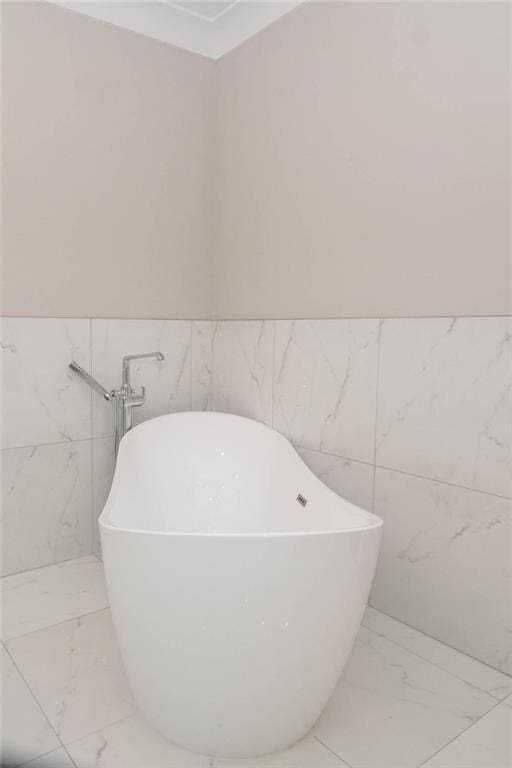 bathroom featuring a bathtub and tile walls