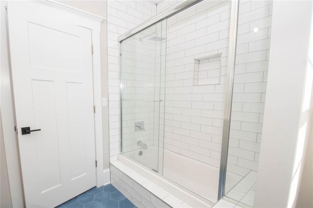 bathroom featuring tile patterned flooring and combined bath / shower with glass door