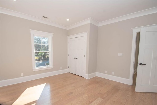 unfurnished bedroom with a closet, light hardwood / wood-style flooring, and ornamental molding