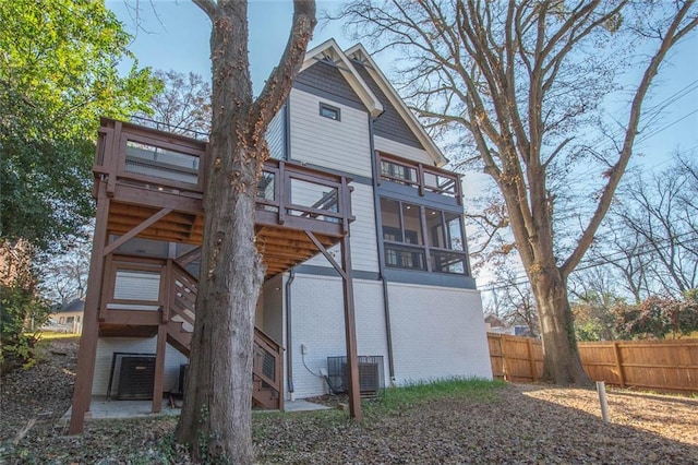 back of house featuring a sunroom and central air condition unit