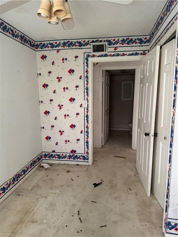 809 Camelot Dr, College Park, GA 30349 - empty room with baseboards, unfinished concrete floors, and wallpapered walls