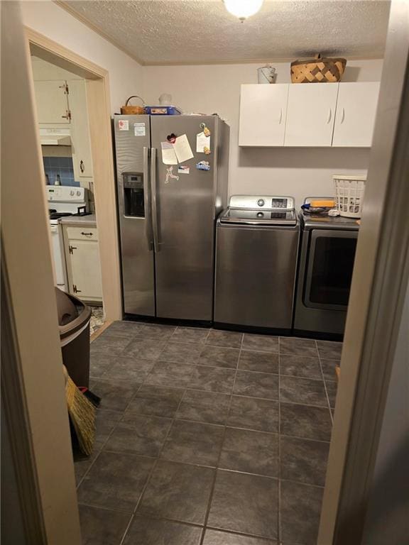 laundry room featuring washing machine and clothes dryer and a textured ceiling