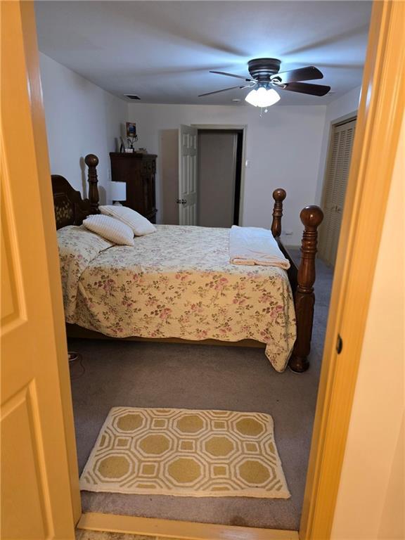 bedroom featuring ceiling fan and carpet