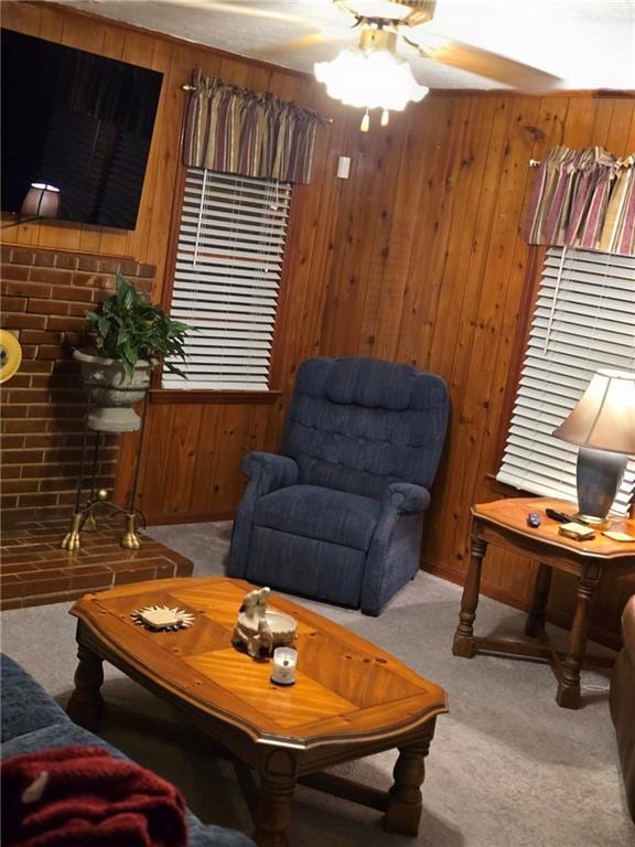 living room with ceiling fan, light carpet, and wood walls