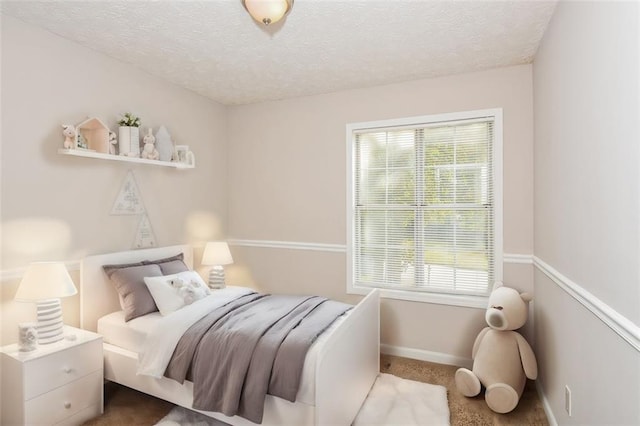 bedroom with a textured ceiling and carpet flooring