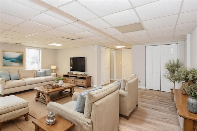 living room with light hardwood / wood-style flooring and a paneled ceiling