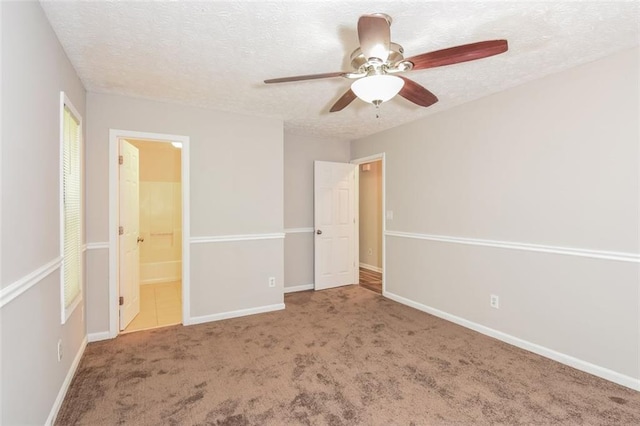 unfurnished bedroom with a textured ceiling, connected bathroom, ceiling fan, and carpet