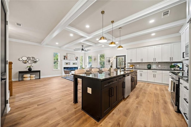 kitchen featuring visible vents, appliances with stainless steel finishes, a kitchen bar, beamed ceiling, and backsplash