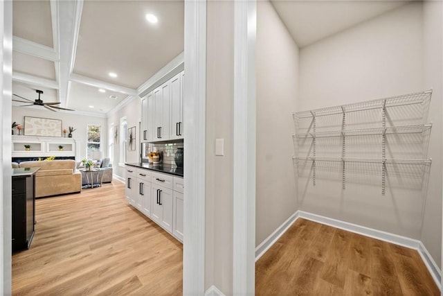 kitchen with backsplash, white cabinetry, and light wood-type flooring