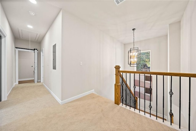 corridor with a chandelier, attic access, carpet floors, electric panel, and an upstairs landing