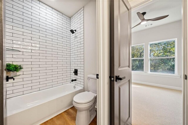 full bathroom with visible vents, toilet, wood finished floors, tub / shower combination, and ceiling fan