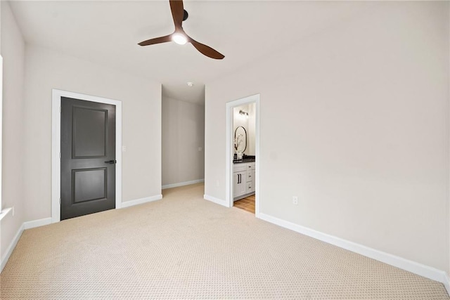spare room with a ceiling fan, baseboards, and light carpet