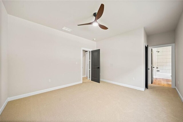 unfurnished bedroom featuring visible vents, light colored carpet, baseboards, and ceiling fan