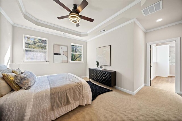 carpeted bedroom with a raised ceiling, baseboards, visible vents, and ornamental molding