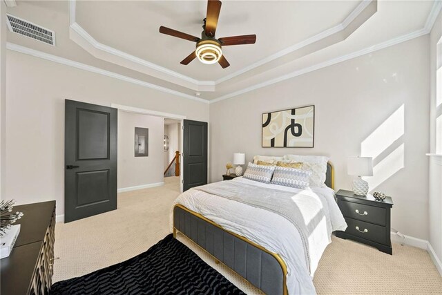 bedroom with baseboards, visible vents, carpet floors, a tray ceiling, and ornamental molding