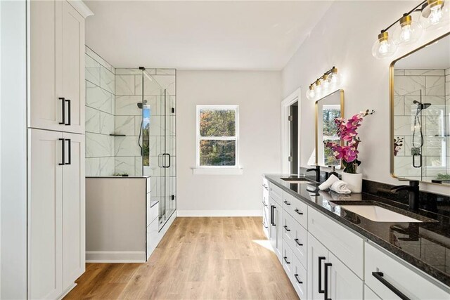 full bathroom with a shower stall, wood finished floors, and a sink