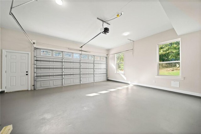 garage featuring a garage door opener and baseboards
