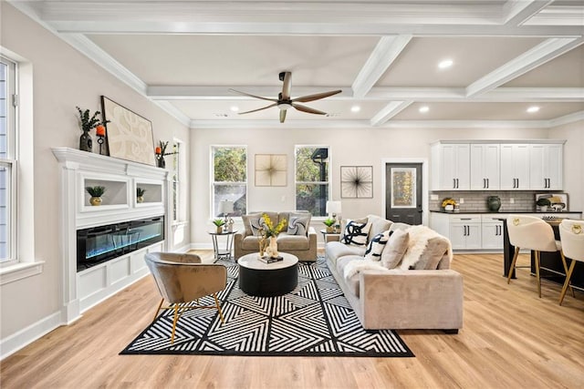 living room with beam ceiling, a glass covered fireplace, light wood-style flooring, and recessed lighting
