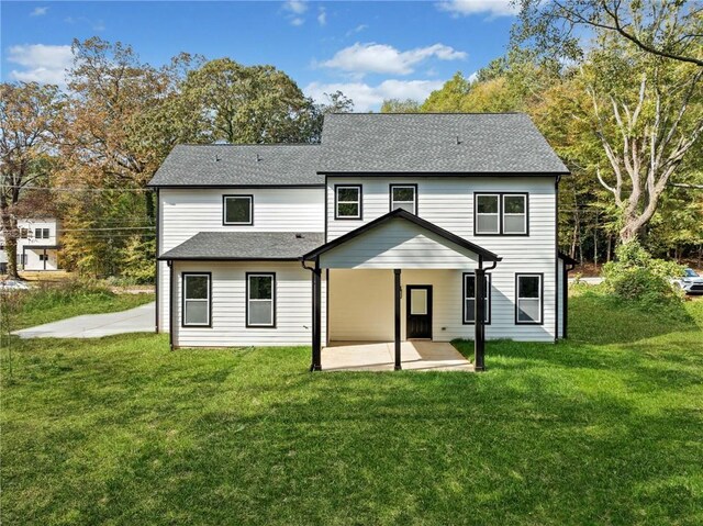 back of house with a patio area, a shingled roof, and a yard