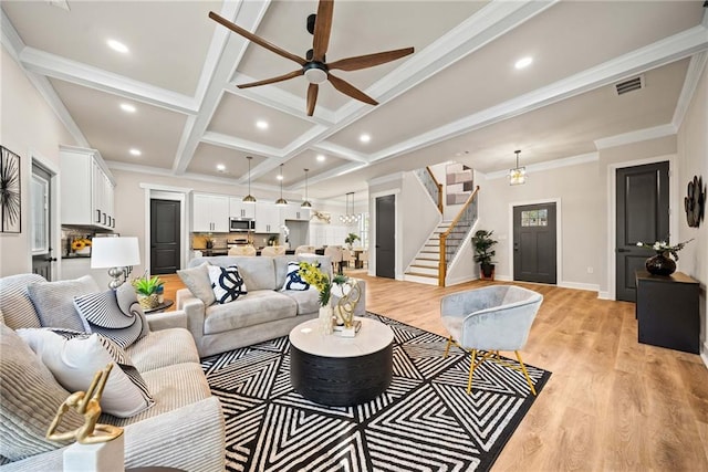 living area with visible vents, beam ceiling, coffered ceiling, stairway, and light wood-style floors