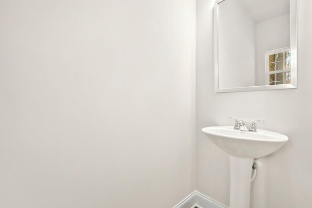 bathroom with a sink and baseboards