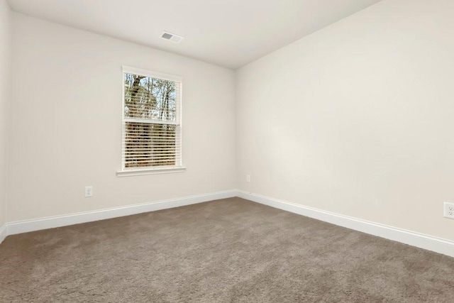 empty room featuring visible vents, carpet, and baseboards