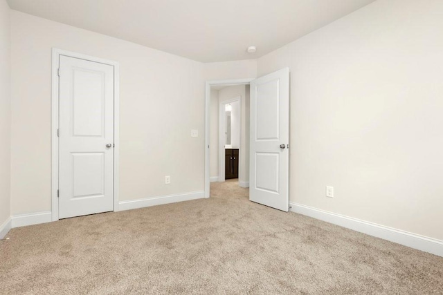 unfurnished bedroom with baseboards and light colored carpet