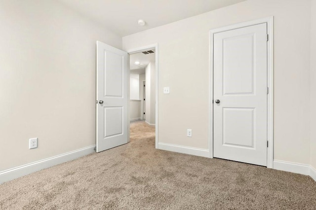 unfurnished bedroom with visible vents, carpet flooring, and baseboards