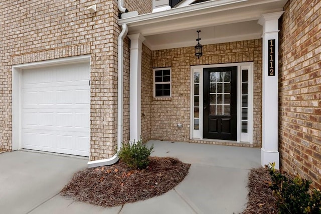 entrance to property with a porch and brick siding
