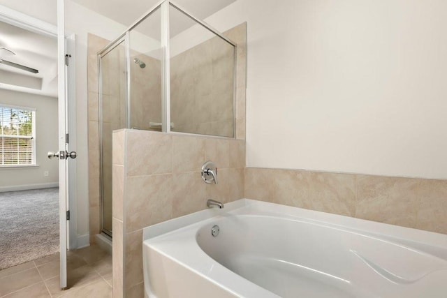bathroom featuring tile patterned flooring, a shower stall, and a bath