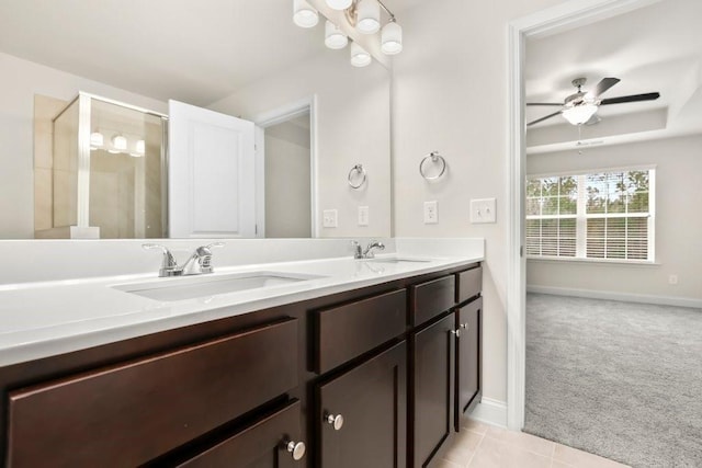 bathroom with a sink, baseboards, a ceiling fan, and double vanity