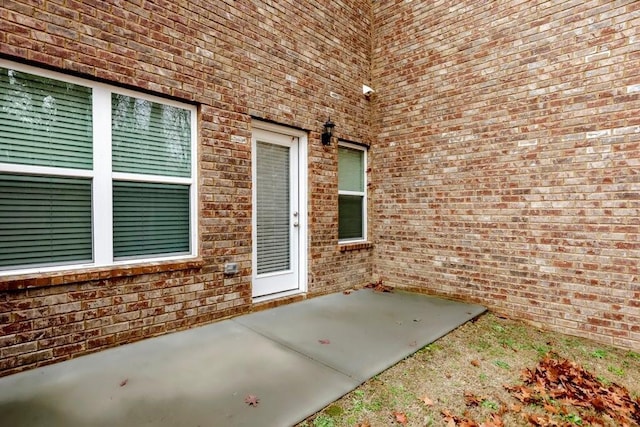 doorway to property with a patio area and brick siding