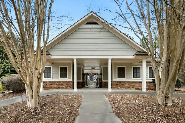 exterior space with brick siding and covered porch