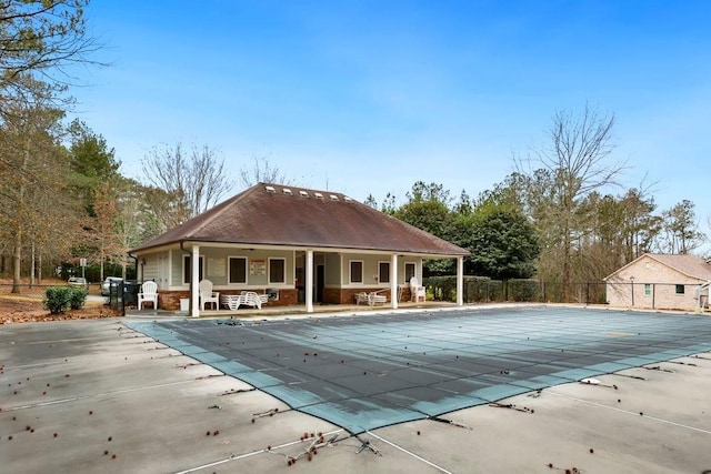 community pool with fence and a patio area
