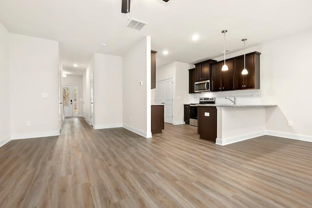 kitchen featuring visible vents, open floor plan, light wood finished floors, and stainless steel appliances