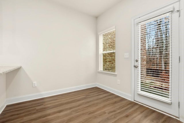 doorway to outside featuring baseboards, wood finished floors, and a wealth of natural light