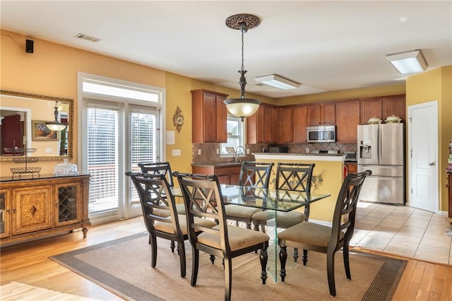 dining room featuring light hardwood / wood-style flooring, a healthy amount of sunlight, and sink