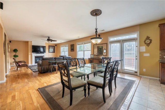 dining room with ceiling fan and light wood-type flooring