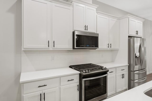 kitchen with white cabinets, backsplash, and stainless steel appliances