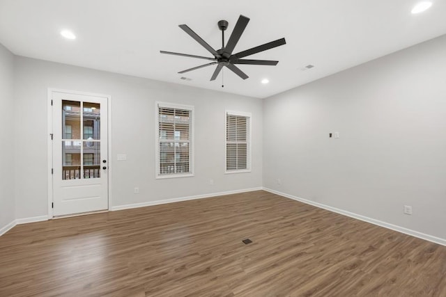 empty room with dark hardwood / wood-style floors and ceiling fan