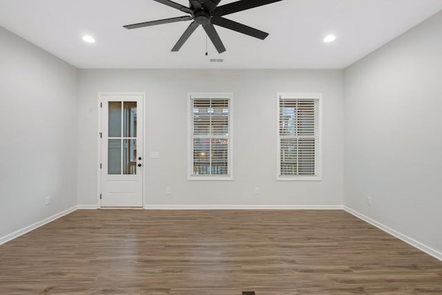 spare room with dark hardwood / wood-style flooring and ceiling fan