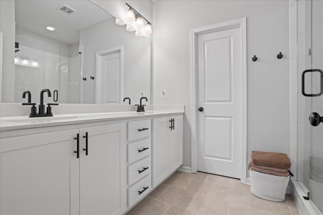 bathroom featuring tile patterned floors, vanity, and a shower with shower door