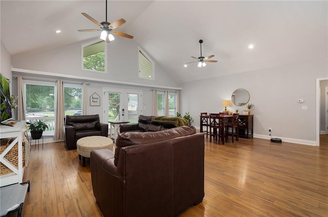 living area with ceiling fan, high vaulted ceiling, recessed lighting, baseboards, and light wood finished floors